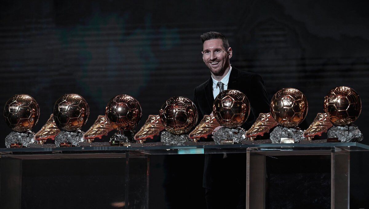 Uradowany Messi stoi za wystawionymi 7 złotymi piłkami i 6 złotymi butami