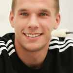 Uśmiechnięty Łukasz Podolski w czarnym dresie