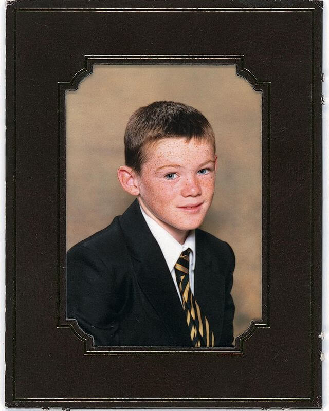 Zdjęcie w ramce, na którym jest nastoletni Wayne Rooney w garniturze z krawatem